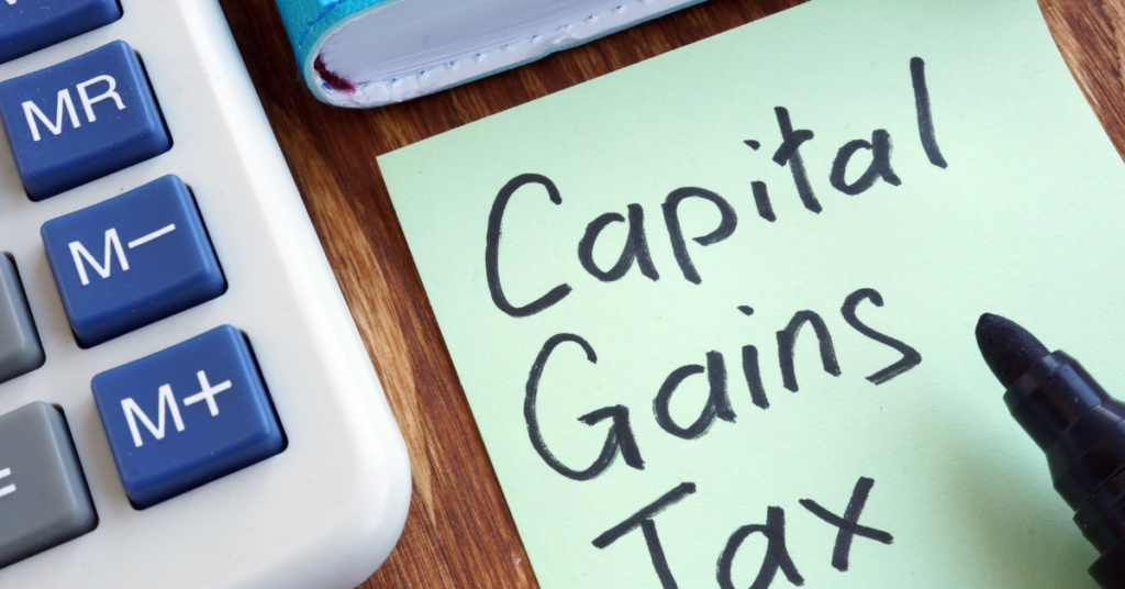 Capital Gains Tax and How To Workout Capital Gains Tax - Image showing a note writing on it Capital Gains Tax and there's a calculator, diary and sign pen on a table.