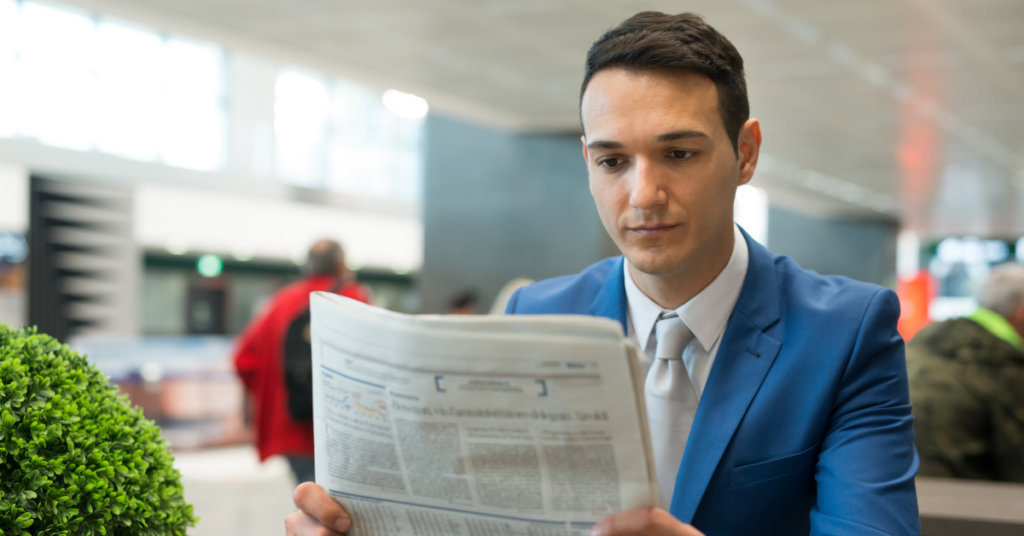 a person reading newspaper about australian property market